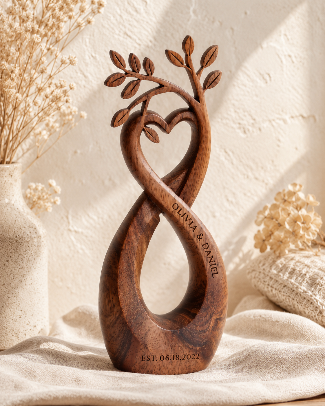 Walnut infinity heart sculpture, front view on textured plaster wall